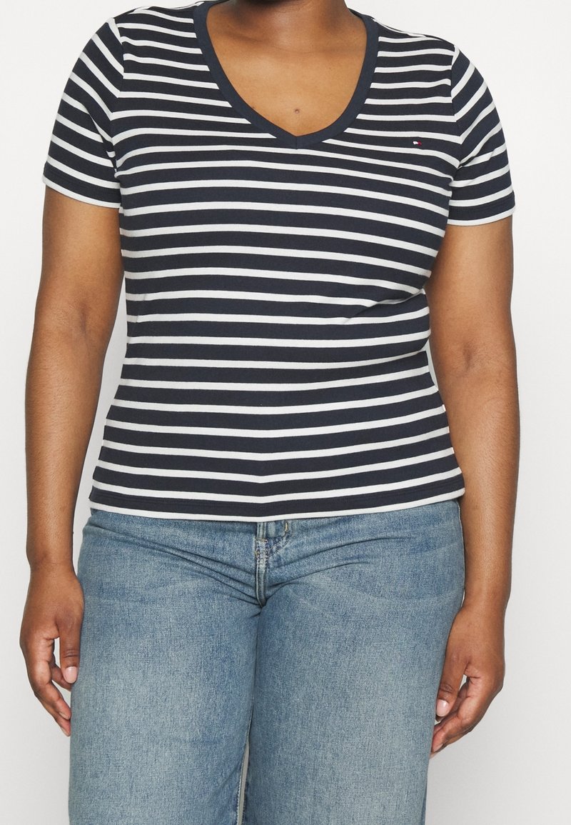 Marineblå og hvide stribede kortærmede V-hals T-shirt lavet af blødt stof, der har en tætsiddende pasform og et lille broderet logo på brystet.