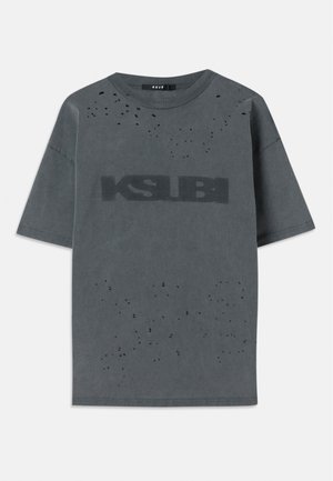 Gray oversized t-shirt made of cotton with distressed accents and a large black "KSUBI" logo on the front. Short sleeves, crew neck design.