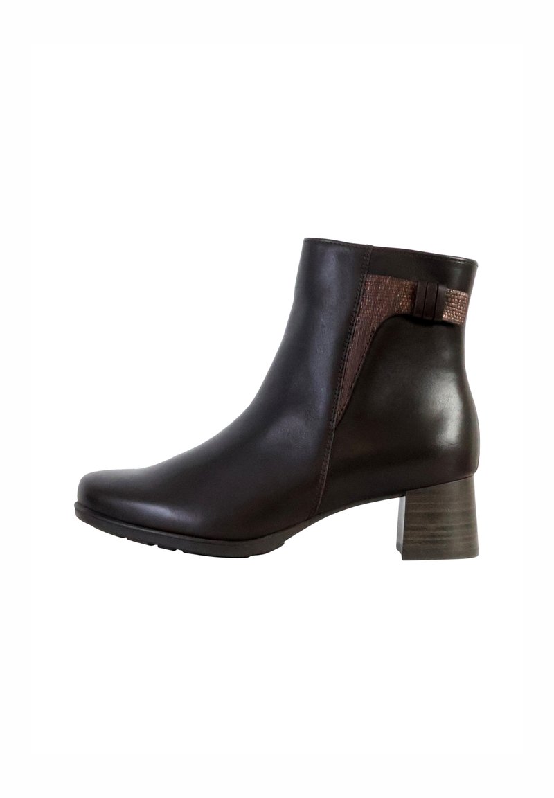 Bottines en cuir marron avec un petit talon carré. Présentent un panneau texturé sur le côté et un design courbé et épuré.