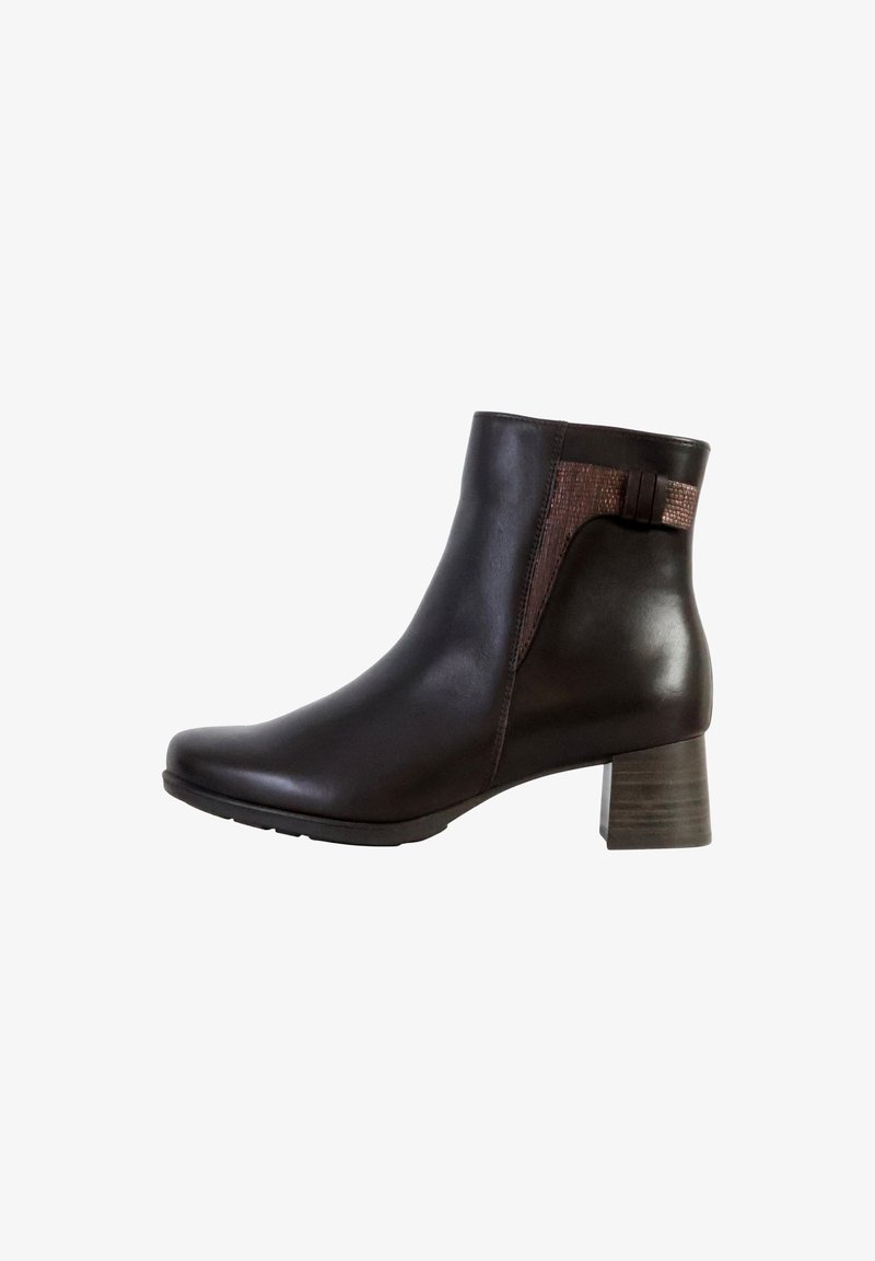 Bottines en cuir marron avec un petit talon carré. Présentent un panneau texturé sur le côté et un design courbé et épuré.