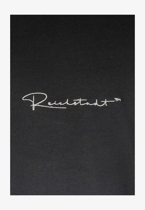 Zwarte stof met een gladde textuur, met in het midden geborduurde witte tekst "Reichstadt™" in een sierlijk schrift.