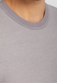 Suéter gris claro de punto con un patrón texturizado. Presenta un cuello redondo y puños acanalados. El material parece suave y transpirable.