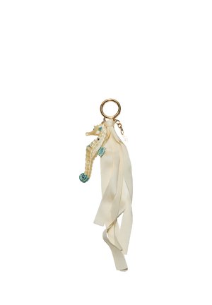 Porte-clés avec breloque hippocampe couleur crème et longs rubans ivoire fluides attachés à un anneau doré.