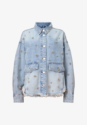 Light blue denim jacket featuring silver floral studs, two chest pockets, a collared neckline, and a frayed hem. Buttons and stitching are visible.