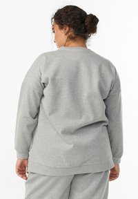Gray sweatshirt with long sleeves, relaxed fit, ribbed neckline, and hem. Soft cotton material, featuring smooth texture without patterns.