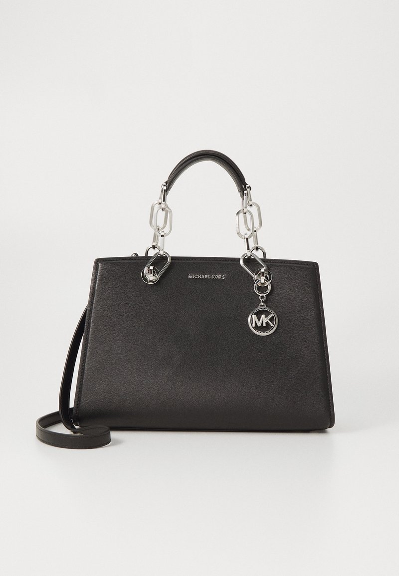 Sac à main structuré noir en matériau texturé. Doté de quincaillerie en argent, de doubles poignées et d'une bandoulière amovible. Charme logo MK attaché.