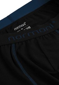 Black boxer briefs with a navy waistband featuring a logo and stitching detail. Soft material with a smooth texture and elastic fit.