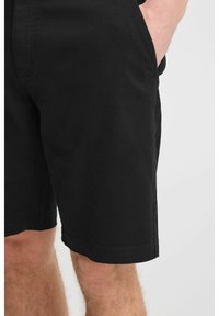 Shorts din bumbac negri, cu o croială lejeră, buzunare laterale și cusături curate. Mâneca este dreaptă, fără modele sau embellisments vizibile.