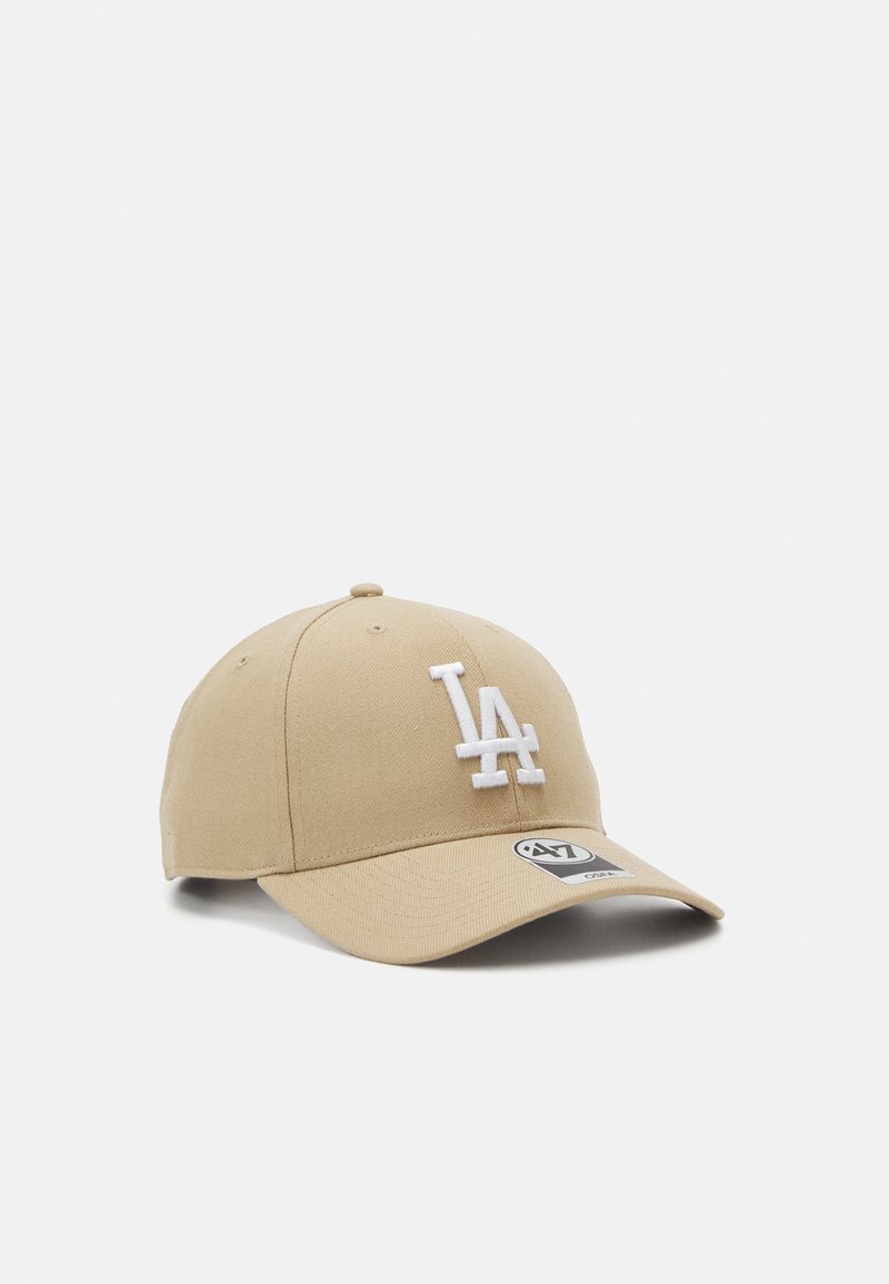Brun baseball cap med hvit "LA" brodering på forsiden. Har en buet skjerm og et stoffmerke på siden. Solid tekstur.