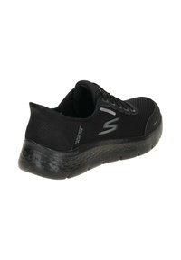Sneaker impermeabile nera con tomaia in rete, tallone rinforzato e suola ammortizzata. Presenta un design testurizzato e il logo Skechers di lato.