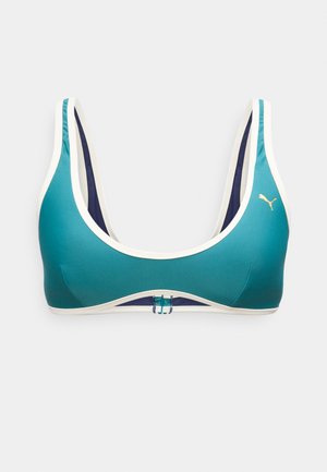 Μπλε σπορ σουτιέν με λευκή επένδυση, εσωτερική φόδρα σε σκούρο μπλε, μπροστινό κούμπωμα και μικρό χρυσό λογότυπο Puma στην αριστερή πλευρά.