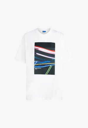 Fehér pamut póló geometrikus grafikai nyomattal, piros, kék és zöld fénycsíkokkal sötét háttéren. Karl Lagerfeld Jeans logóval ellátva.