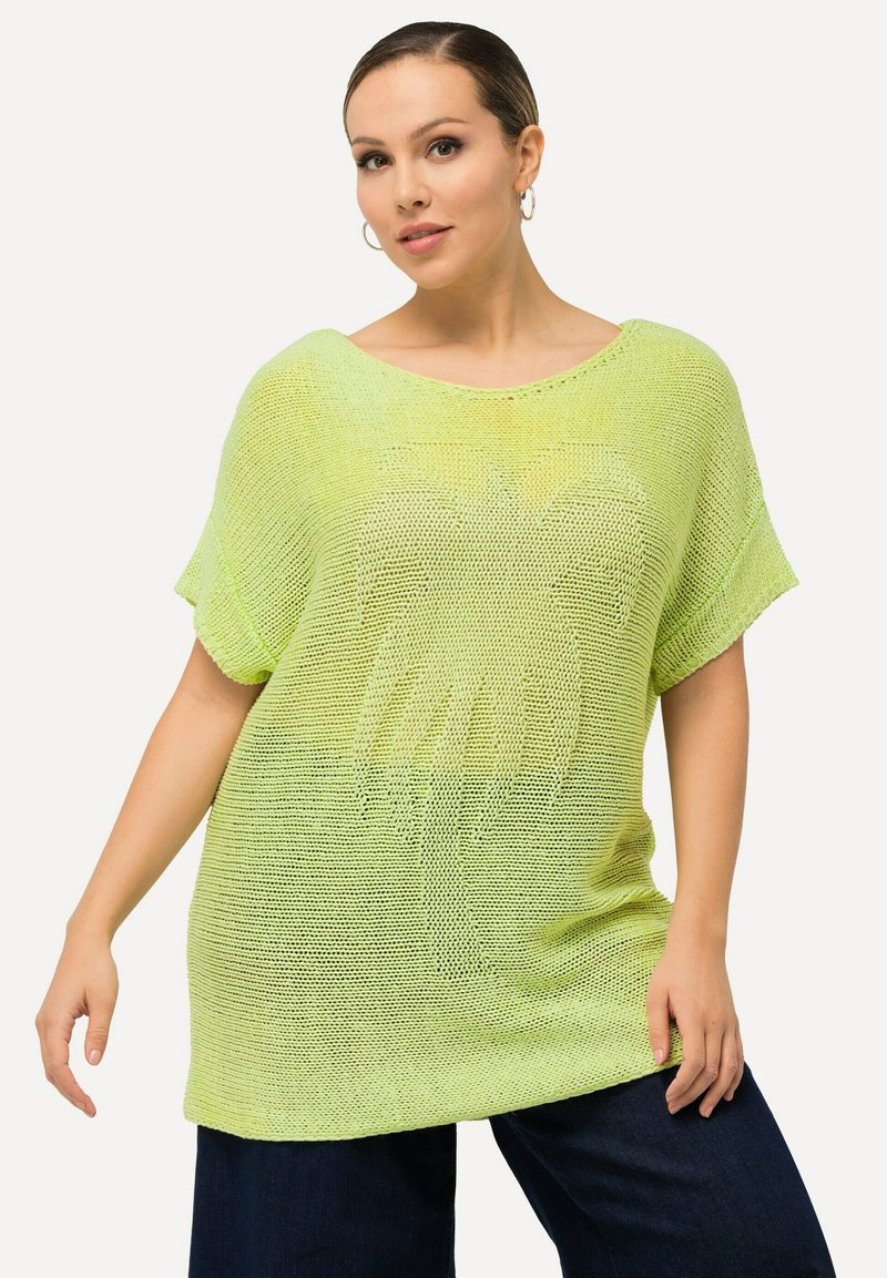 Limegrünes, oversize gestricktes Oberteil mit kurzen Ärmeln, das ein strukturiertes Muster aufweist. Der Stoff scheint leicht und atmungsaktiv zu sein.