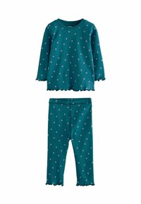 Teal pyjamas med långärmad topp och byxor; har spridda rosa hjärtformer och ruffled kanter. Tillverkad av mjukt, stretchigt tyg.