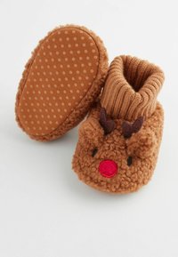 Bruna fleece-tofflor med röd nos, svarta ögon och stickad tan cuffs som liknar en ren. Prickig gummisula för bättre grepp.