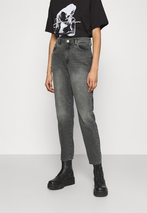 Jeans grises de cintura alta con un ligero desvanecimiento, diseño de pierna recta y cinco bolsillos, combinados con una camiseta gráfica negra y botas negras de cordones.