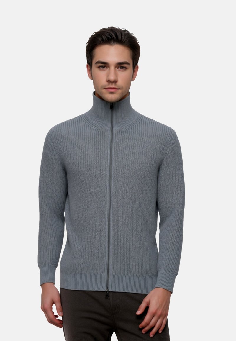 Light gray ribbed zip-up sweater with a high collar, featuring a smooth texture and fitted design. Zipper runs vertically down the front.