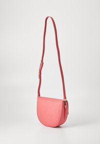 Pink leather crossbody bag with a rounded shape, embossed logo pattern, adjustable strap, and gold-tone hardware accents.