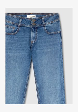 Jasnoniebieskie dżinsy o gładkiej fakturze, z podwójnym zapięciem na guziki, pięcioma kieszeniami oraz kontrastującymi pomarańczowymi szwami.