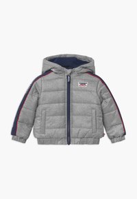 Grå dunjakke med hætte, med marineblå detaljer og røde striber langs ærmerne, lynlås foran og elastiske manchetter. Levi's logo vist.