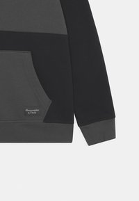 Pullover sweatshirt in een grijs en zwart katoenmix. Heeft een voorkant zak, ribgebreide boorden en een geborduurd logo op de zak.