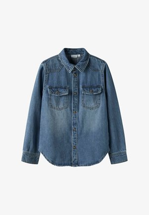 Sinine teksariidest särk, pikkade varrukatega, terava kraega ja kahe eesmise taskuga. Omab metallnuppe ja veidi kaardus allääri.