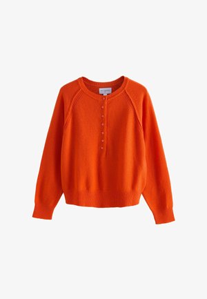 Orange knit sweater with a round neckline, raglan sleeves, and a button placket. Ribbed cuffs and hem add texture and structure.