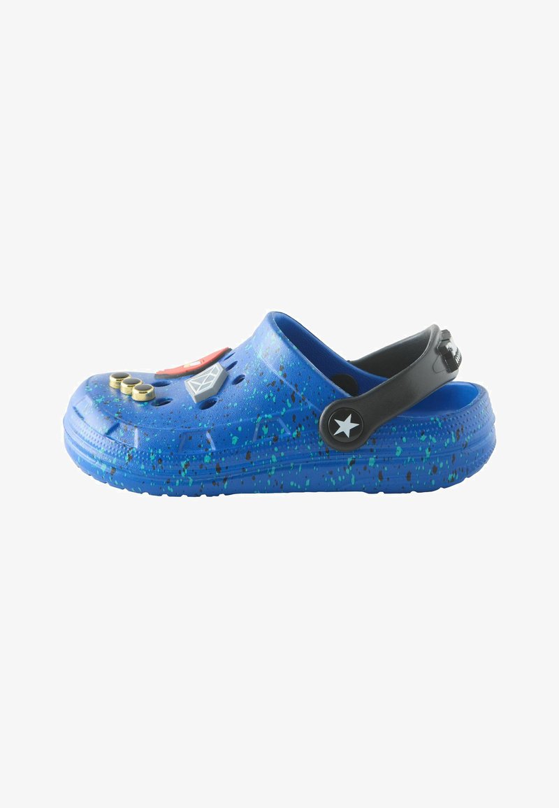 Sabot bleu moucheté avec bride arrière réglable noire, décoré de divers charms colorés sur le dessus.