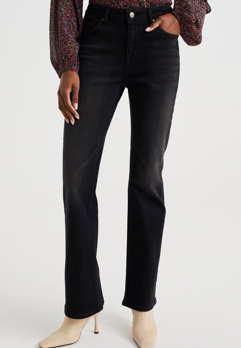 Jeans di denim nero a vita alta con design a gamba dritta, dotati di passanti per cintura, tasche anteriori e una texture leggermente sbiadita.