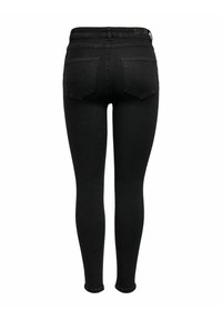 Jean skinny noir taille haute avec poches arrière et passants de ceinture, montré de dos sur fond blanc.