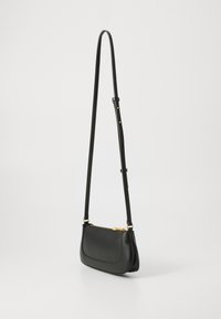 Geantă din piele neagră tip crossbody cu curea ajustabilă și detalii cu fermoar aurie, pe un fundal alb simplu.
