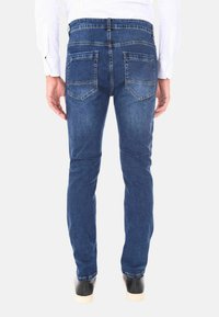 Jeans da uomo in denim blu, slim fit, con vita media, due tasche posteriori e dettagli di cucitura classici. Texture liscia.