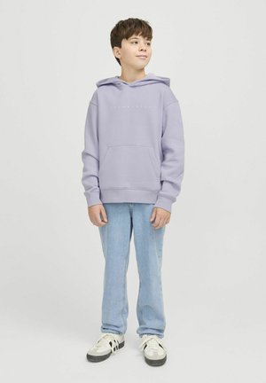 Haut à capuche lilas avec poche kangourou et cordon de serrage, associé à un jean bleu clair et des baskets multicolores. Texture lisse, coupe décontractée.