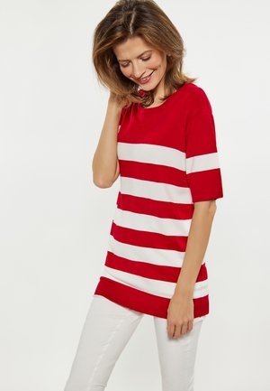 Maglione a righe rosse e bianche con scollo rotondo e maniche corte. Il tessuto è liscio e presenta orli e polsini a coste.