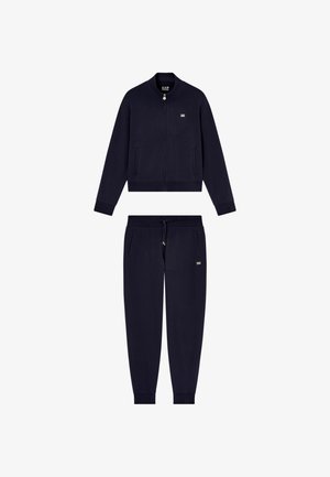 Navy blue two-piece tracksuit with zipper jacket, elastic cuffs, and drawstring pants, featuring small EA7 logos on chest and pocket.