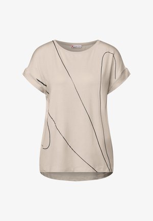 T-shirt beige con scollo rotondo e maniche corte arrotolate. Presenta motivi astratti di linee nere sulla parte anteriore. Tessuto morbido e liscio.