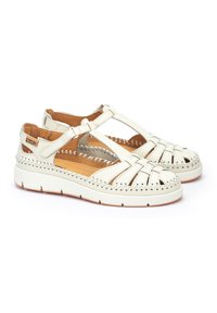 Sandalias de cuero blanco con tiras trenzadas, diseño de punta abierta, plantilla acolchada y suela de goma texturizada con sutilezas en los detalles de costura.