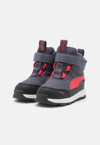 Grau und schwarze Mid-Top-Sneaker mit roten Akzenten. Verfügt über einen gepolsterten Kragen, einen Klettverschluss und eine Gummisohle für bessere Traktion.