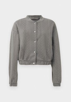 Giacca grigia corta con un motivo testurizzato, dotata di colletto rotondo, maniche lunghe e chiusure a bottone a pressione lungo la parte anteriore.