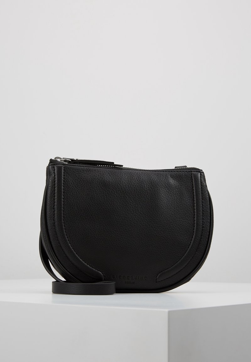 Borsa a tracolla nera in pelle con forma arrotondata, finitura texturizzata, chiusura con zip superiore e una tracolla removibile. Presenta un branding discreto.