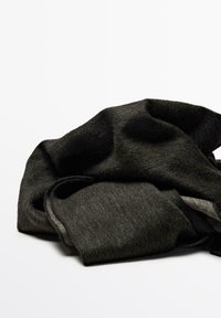 Tissu en laine noir, froissé et superposé, présentant une texture douce et des teintes variées. Les bords sont légèrement effilochés, mettant en valeur son apparence naturelle.