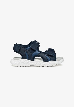 Sandalo blu navy con punta aperta, cinturini in Velcro regolabili e suola bianca testurizzata progettata per comfort e utilizzo casual.