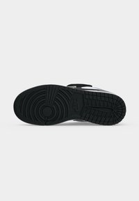 Μαύρη σόλα αθλητικού παπουτσιού Nike με κυκλικά και πλεγμένα πέλματα σε απλό λευκό φόντο.
