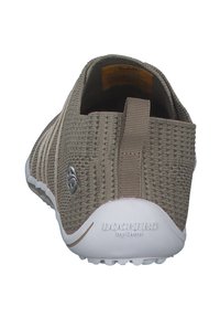 Tan mesh slip-on shoe with a textured upper, elastic accents, and a white, treaded sole. Features a logo on the side and a pull tab at the back.