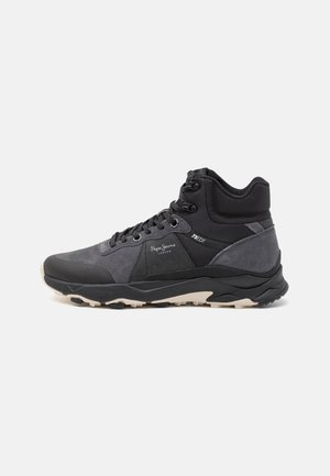 Schwarze und dunkelgraue High-Top-Sneaker aus Wildleder und Mesh, mit Schnürverschluss, strukturiertem Gummisohle und Branding an der Seite.
