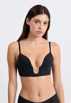Reggiseno nero con scollatura profonda e spalline sottili regolabili. Tessuto liscio ed elastico con design senza cuciture. Scollatura bassa sul davanti per una maggiore versatilità del capo.