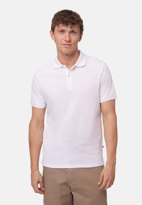 Polo shirt bianco a maniche corte con colletto classico, realizzato in cotone, caratterizzato da un piccolo logo sul petto e orlo dritto.