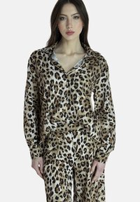 Blusa de seda con estampado de leopardo, de corte relajado, con frente abotonado y mangas largas. Presenta un cuello y puños de satén azul claro.