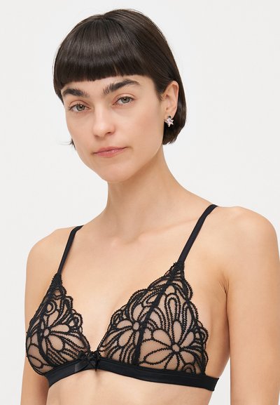 Bralette en dentelle noire avec un motif floral, bonnets transparents et bande en satin. Bretelles réglables et un petit nœud décoratif au centre.