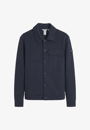 Dark navy blue casual jacket with snap buttons, single flap chest pocket, side pockets, and collar, labeled "AM" on the left sleeve.